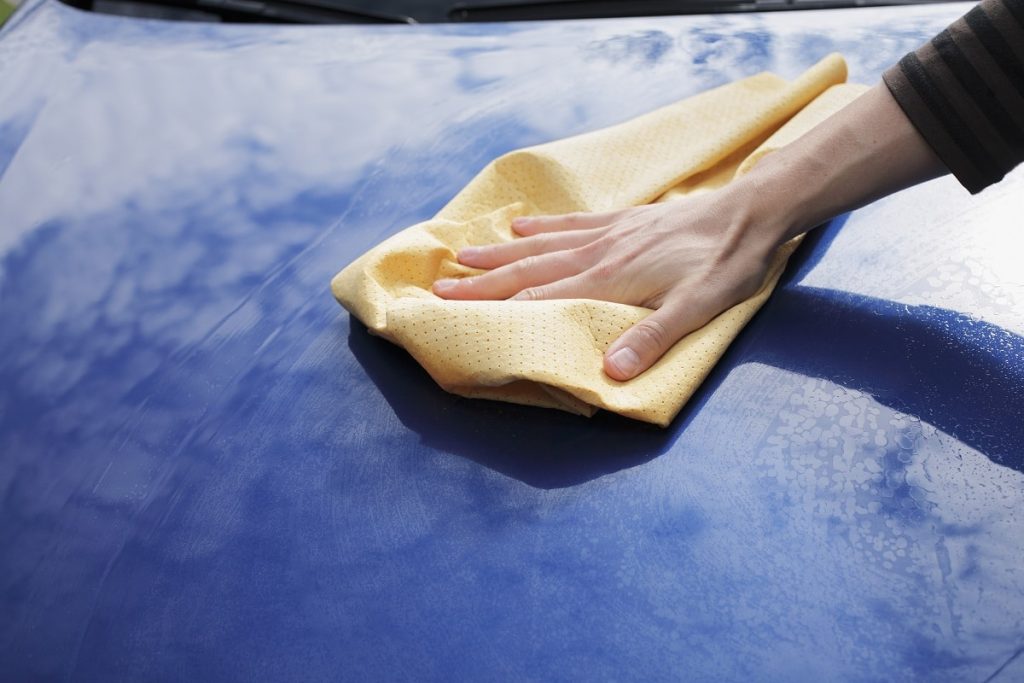 Water spots being removed while exterior detailing is done on a car